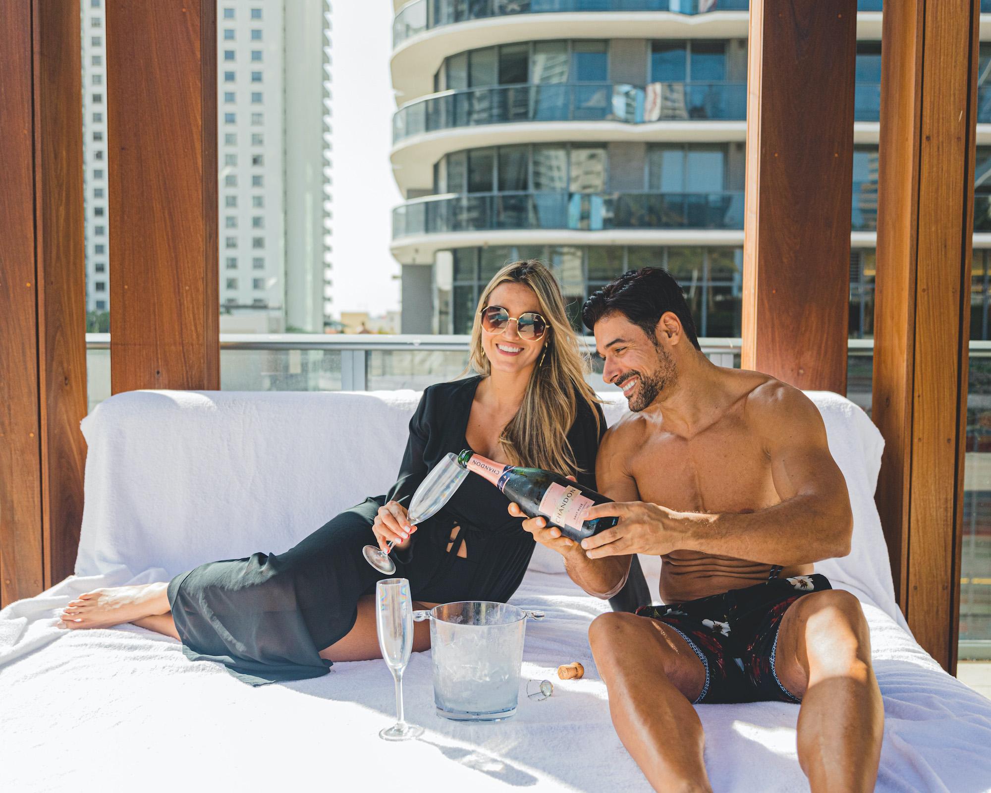 couple sitting on bed pouring champagne