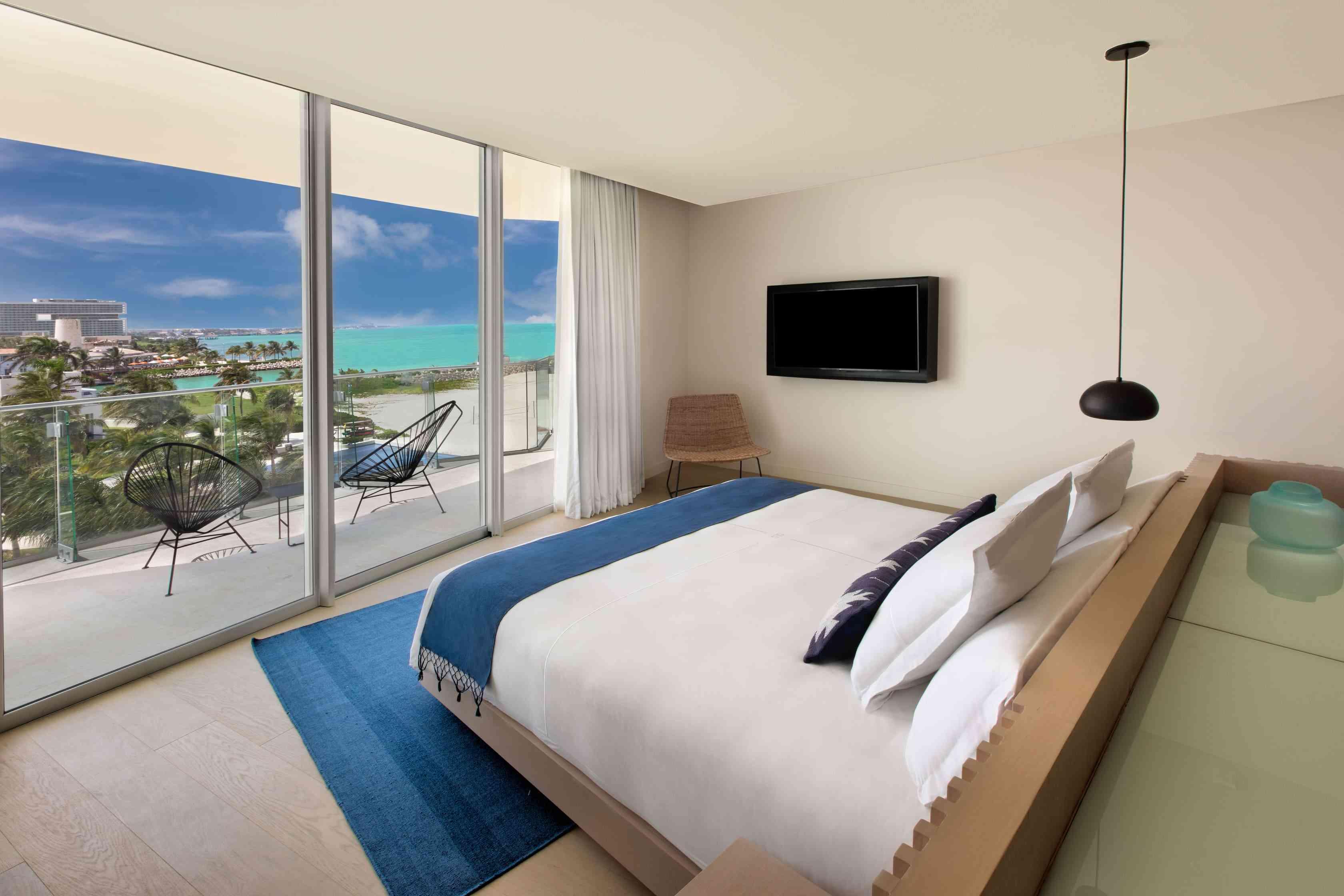 Bedroom with bed facing the balcony which overlooks the ocean