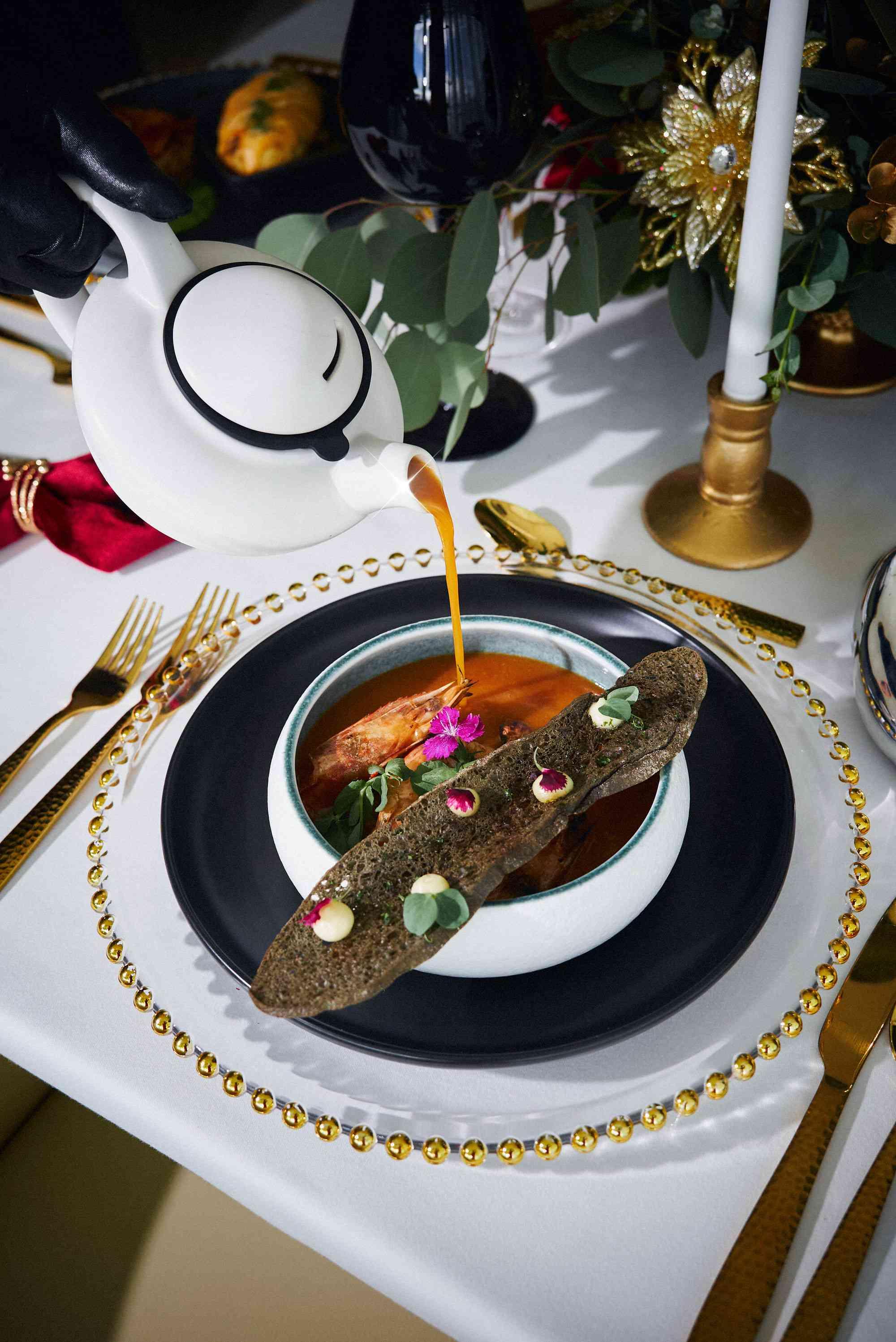 Festive table scape with someone pouring soup into a bowl
