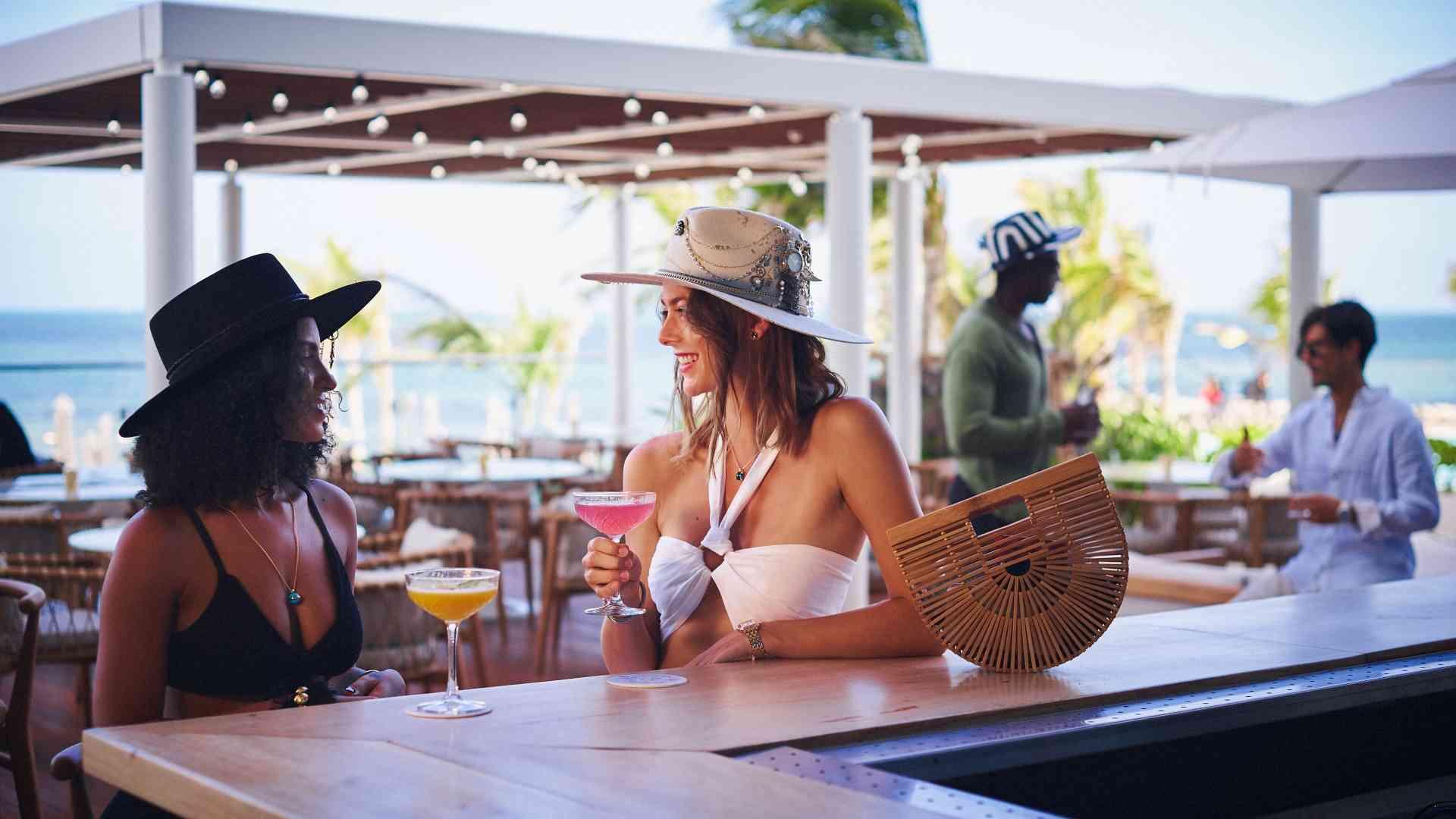 Women sitting at the outdoor bar with cocktails
