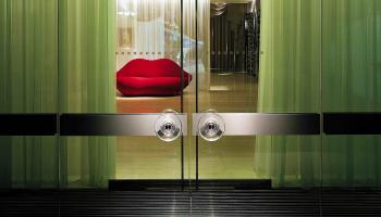 Entrance to hotel with red lip couch in background