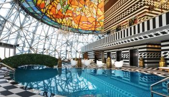 Pool surrounded by black and white floor and colorful glass ceiling