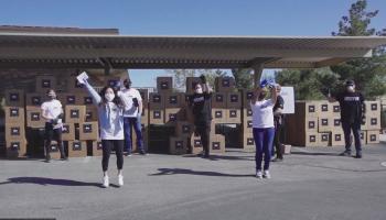 group of people in white tshirts handing out care package boxes
