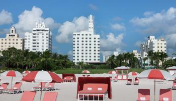 brightly colored beach chairs and umbrellas on a white sand beach