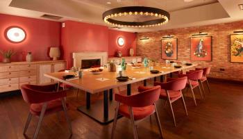 Salmon coloured room with a dining room table 