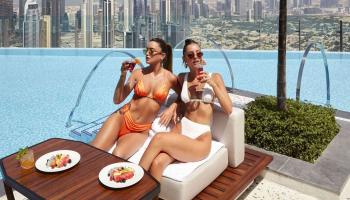 two women eating by the pool