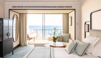 Large room with full wall windows overlooking the ocean