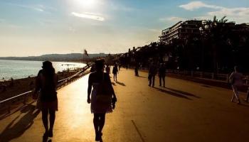 woman walking down the beach at sunset