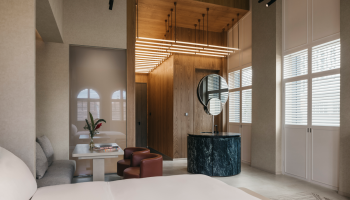 Mondrian Singapore contemporary hotel room featuring a bed, desk, mirror and socializing area