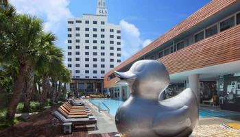 giant duck sculpture in front of pool 