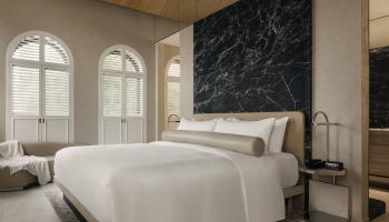 Mondrian Singapore Duxton hotel suite with king bed and large window.