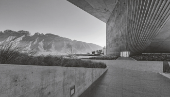 balck and white photo of a landscape with mountains and a building