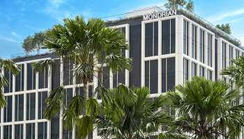 Mondrian Singapore Duxton building nestled amidst lush palm trees, creating a serene and tropical ambiance.